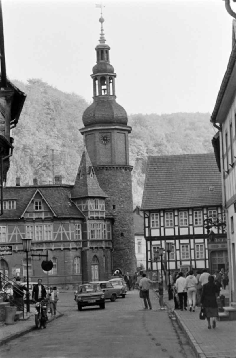 View along Rittergasse towards the market with the Seigerturm in Stolberg (Harz) in the southern Harz region in the federal state of Saxony-Anhalt in the territory of the former GDR, German Democratic Republic. Cars drive on the street, passers-by crowd the pavement