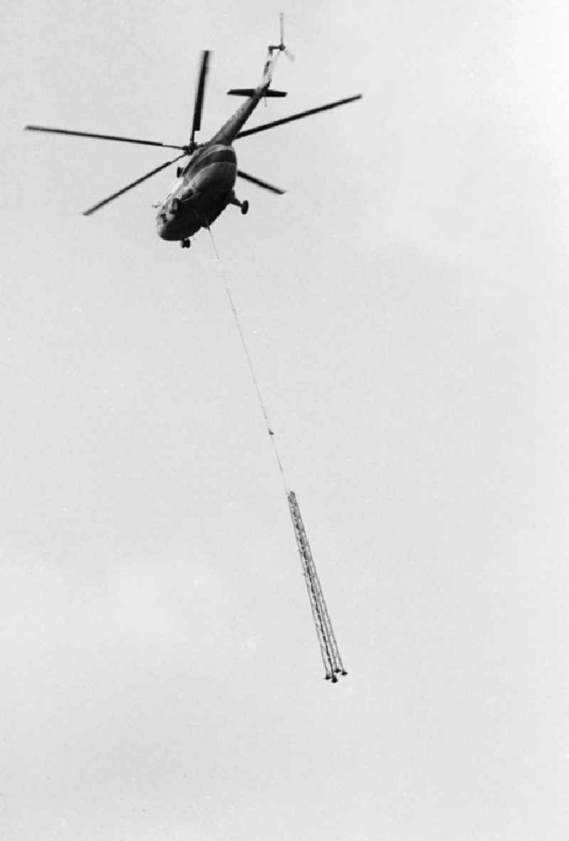 A transport helicopter of the type Mi8 transports driving poles in Seddiner See in the federal state Brandenburg in the area of the former GDR, German democratic republic