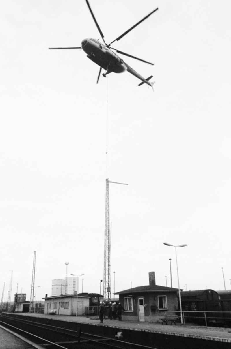 A transport helicopter of the type Mi8 transports driving poles to the railway station Seddin of the German national railway in Seddiner See in the federal state Brandenburg in the area of the former GDR, German democratic republic