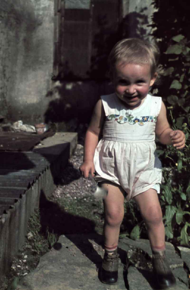 Kleinkind spielt im Garten. Plying infant in a garden.