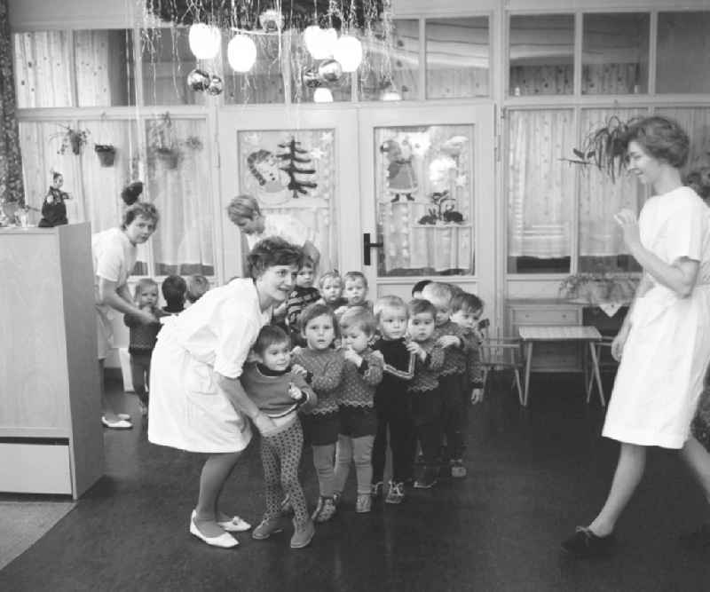 Everyday life in a baby cot in Silbitz in today s state of Thuringia. Children stand in a row, along with nursery nurse in white coats