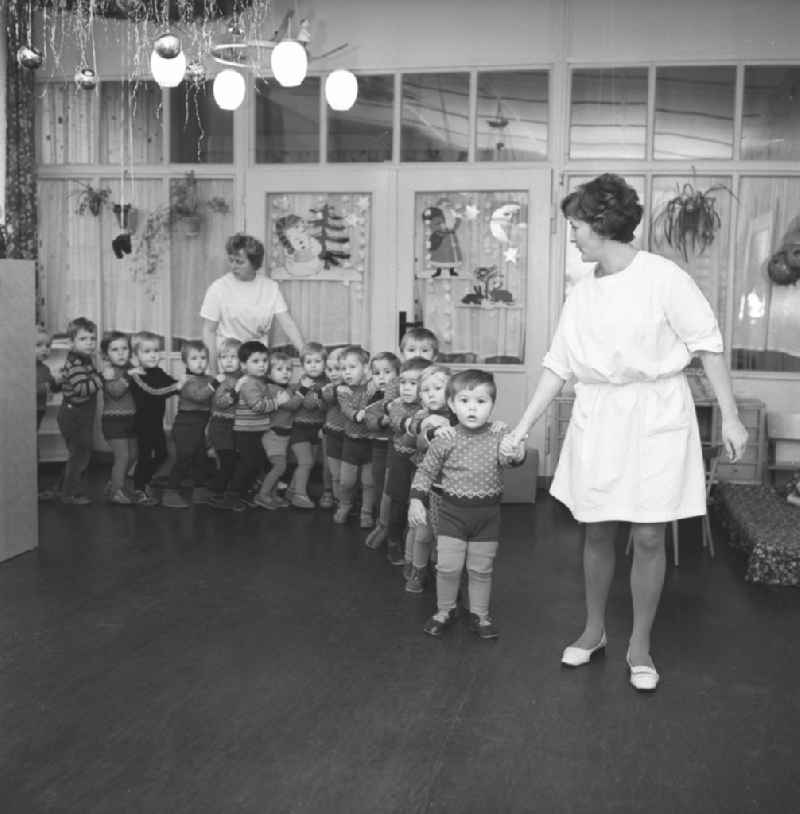 Everyday life in a baby cot in Silbitz in today s state of Thuringia. Children stand in a row, along with nursery nurse in white coats