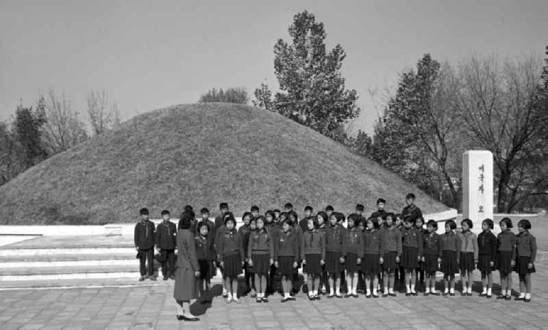 Nordkoreanische Pioniere stehen vor einem Massengrab-Hügel im Sinchon-Museum über US-Amerikanische Kriegsverbrechen in der der Koreanischen Demokratischen Volksrepublik KDVR - Nordkorea / Democratic People's Republic of Korea DPRK - North Korea.