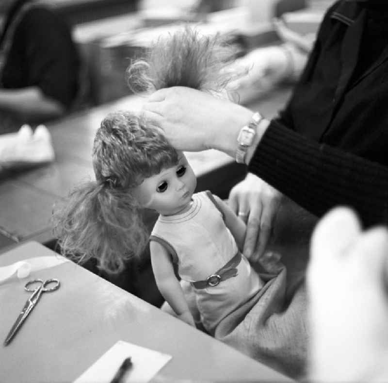 Eine Mitarbeiterin des VEB Kombinat Spielwaren Sonneberg 'sonni' frisiert eine fertige Puppe, bevor sie für den Verkauf verpackt wird. Die Sonneberger Puppen waren nicht nur in der DDR beliebt, sondern trugen den Namen der Stadt in alle Welt.