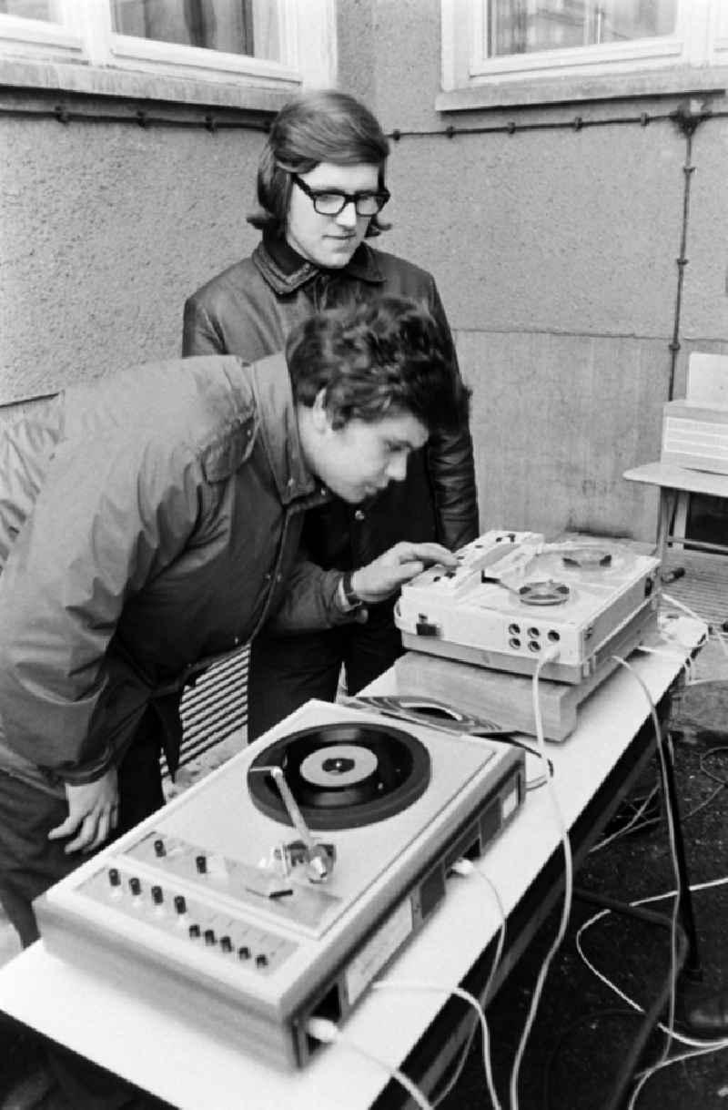Two students operate a music system at an auction on a schoolyard in Spremberg in the federal state of Brandenburg on the territory of the former GDR, German Democratic Republic