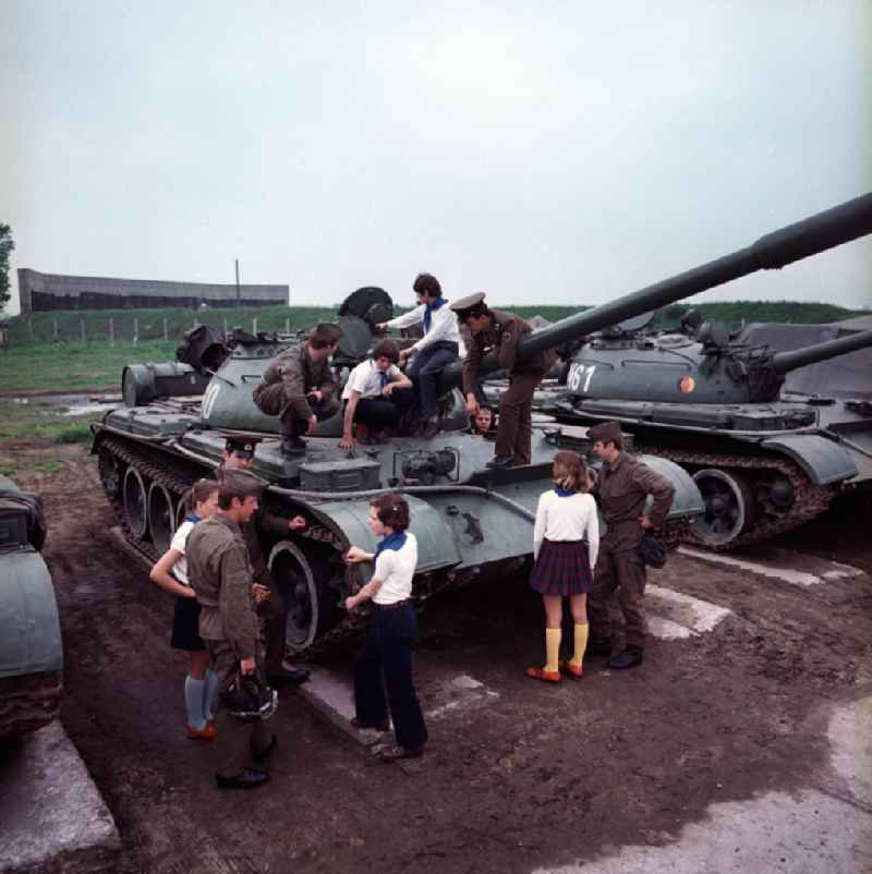 Pionier, Soldaten und Offiziere der NVA / Nationalen Volksarmee neben sowie auf einem Panzer vom Typ T-55, ein russischer mittlerer Panzer, anlässlich eines Besuchs / Wandertag der Schüler. Hier werden alle Fragen der Jungpioniere beantwortet. Die Schüler tragen alle das Blaue Halstuch / Uniform.