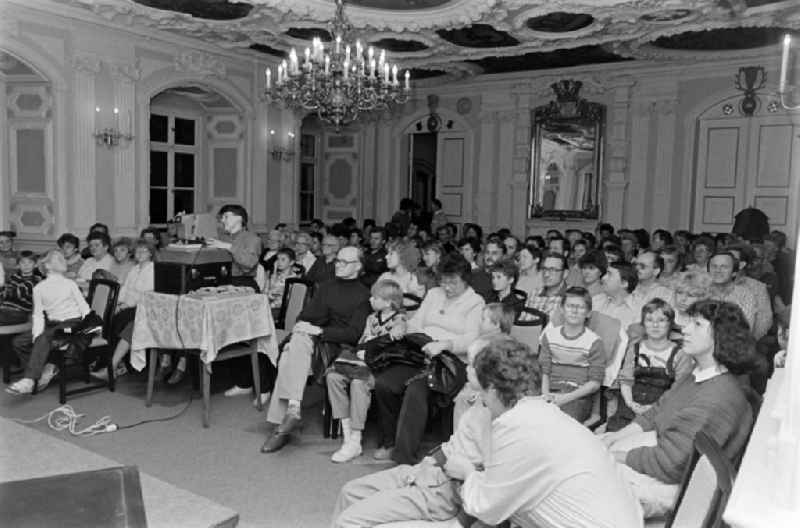 Families watch a slide show in the FDGB holiday home ' Comenius ' in the castle in Stolberg (Harz) in the federal state of Saxony-Anhalt in the territory of the former GDR, German Democratic Republic