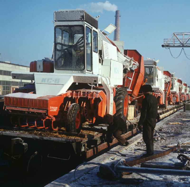 Fertiggestellte Rübenerntemaschinen vom Typ KS-6 werden auf dem Verladebahnhof des Kombine-Werk Ternopol (heute Ternopil / Ukraine) für den Transport vorbereitet. Der KS-6 (russisch KC-6) war eine Gemeinschaftsentwicklung der DDR und der Sowjetunion und wurde in viele sozialistische Staaten geliefert. Der Großteil der Baugruppen kam aus dem VEB Kombinat Fortschritt Weimar. Die Endmontage fand in Ternopol statt.
