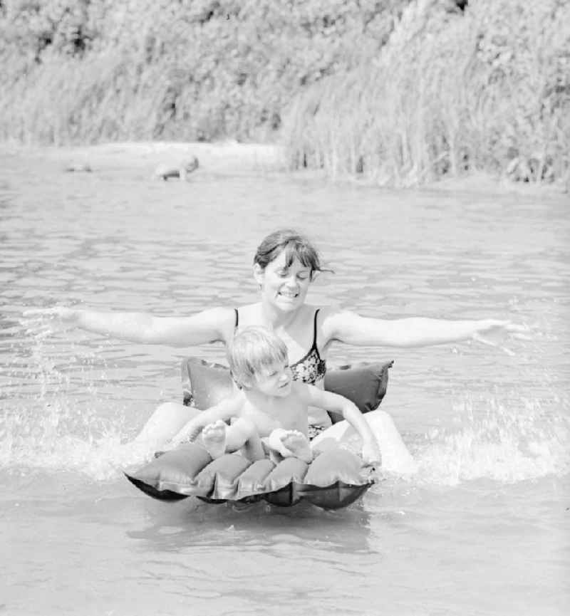 Woman with child on an air mattress on the Teupitzer lake in Teupitz in Brandenburg on the territory of the former GDR, German Democratic Republic