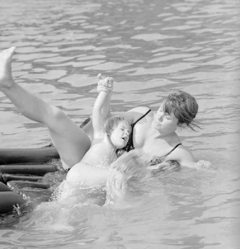 Woman with child on an air mattress on the Teupitzer lake in Teupitz in Brandenburg on the territory of the former GDR, German Democratic Republic