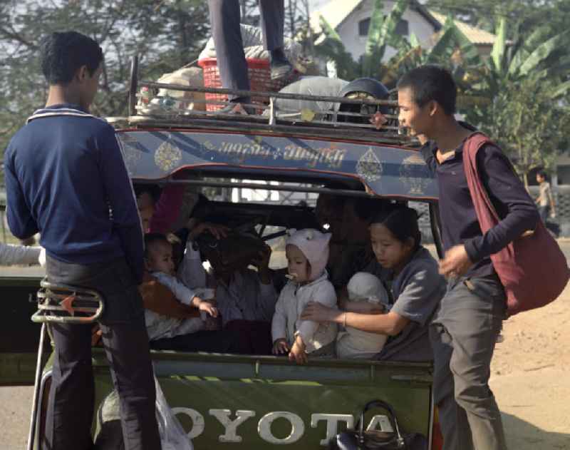 Ein mit Menschen und Waren vollbeladener PKW  / Auto / Taxi der Marke Toyota steht auf einer Straße in Vientiane, der Hauptstadt der Demokratischen Volksrepublik Laos.
