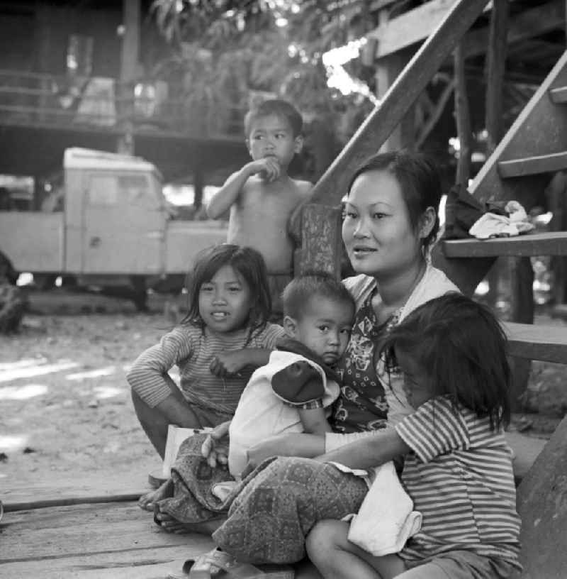 Eine Familie vor ihrem Haus in einem Dorf nördlich von Vientiane, der Hauptstadt der Demokratischen Volksrepublik Laos.