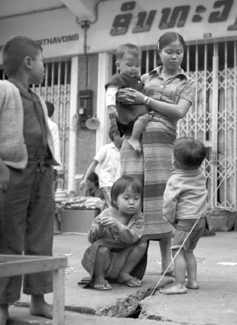 Eine Frau mit ihren Kindern auf einer Straße in Vientiane, der Hauptstadt der Demokratischen Volksrepublik Laos.
