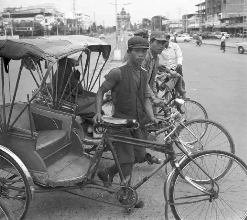 Rikschafahrer stehen an einer Straße in Vientiane, der Hauptstadt der Demokratischen Volksrepublik Laos.