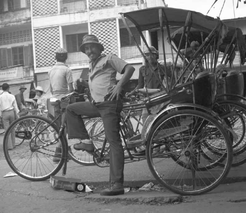Rikschafahrer stehen an einer Straße in Vientiane, der Hauptstadt der Demokratischen Volksrepublik Laos.