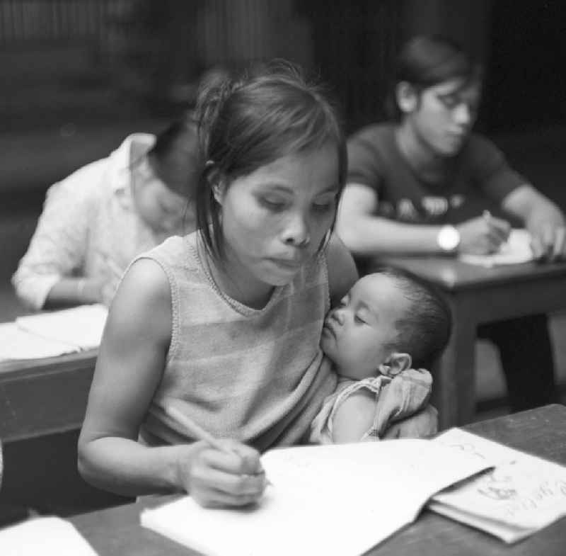Frauen lernen in einer Schule schreiben und lesen. Nach der Gründung der Volksrepublik Laos im Dezember 1975 wurde das Schulsystem von der neuen kommunistischen Regierung in Laos wieder aufgebaut, um dem in der Bevölkerung weit verbreiteten Analphabetismus entgegenzuwirken.