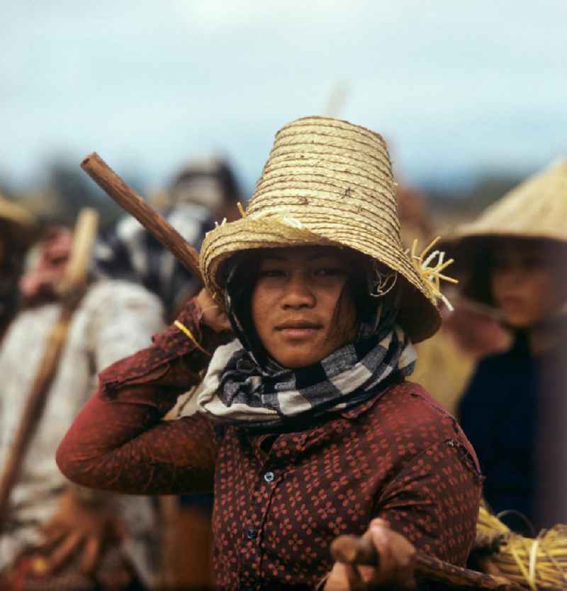 Frauenporträt bei der Reisernte auf einem Feld in der Demokratischen Volksrepublik Laos.