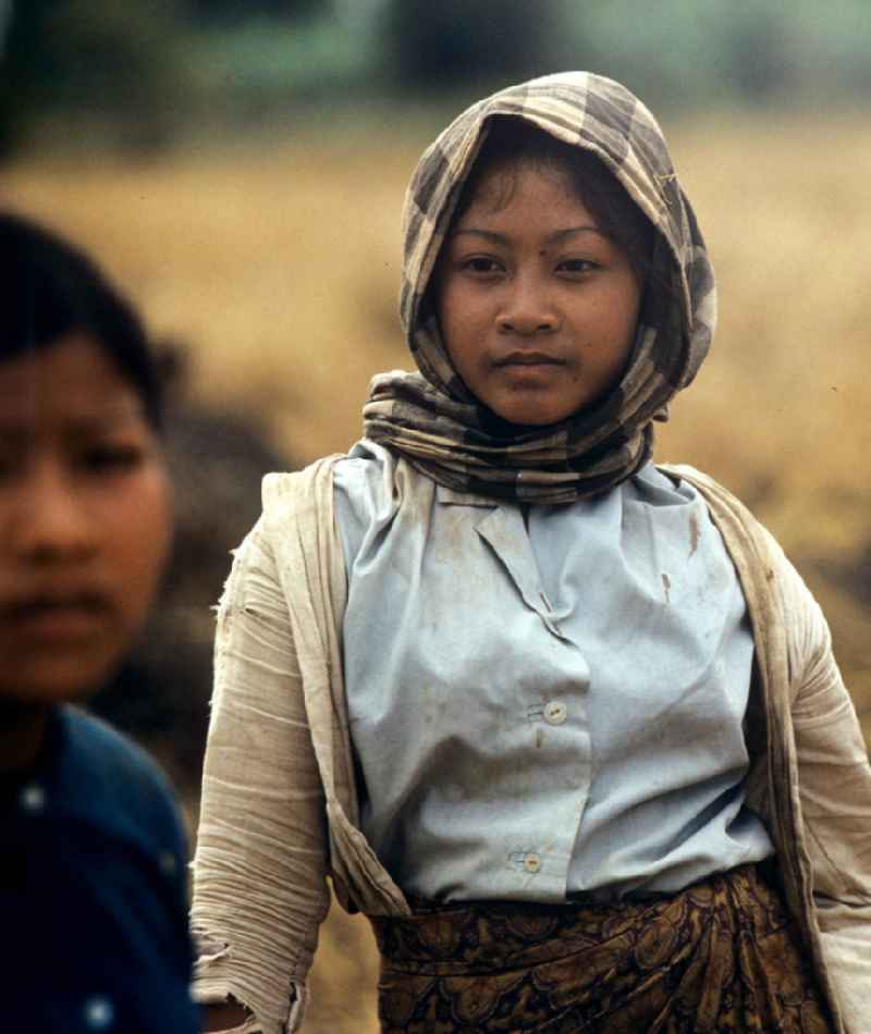 Frauenporträt bei der Reisernte auf einem Feld in der Demokratischen Volksrepublik Laos.