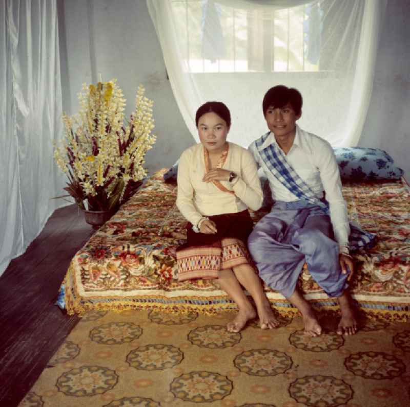 Brautpaar auf dem Ehebett während der Hochzeitsfeier in einem Dorf in der Demokratischen Volksrepublik Laos.