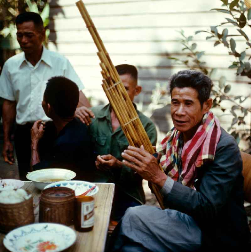 Ein Mann spielt auf einer Khaen zu einer Hochzeit in einem Dorf in der Demokratischen Volksrepublik Laos. Die asiatische Mundorgel ist das Nationalinstrument der Lao in Laos.