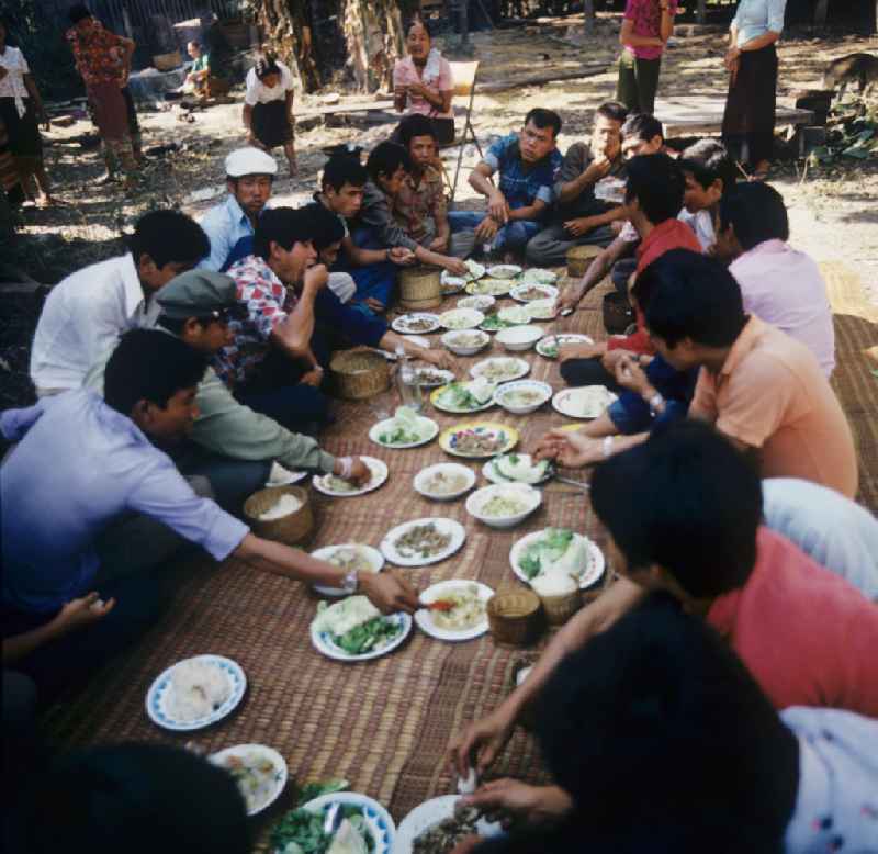 Männer beim Essen auf einer Hochzeitsfeier in einem Dorf in der Demokratischen Volksrepublik Laos.
