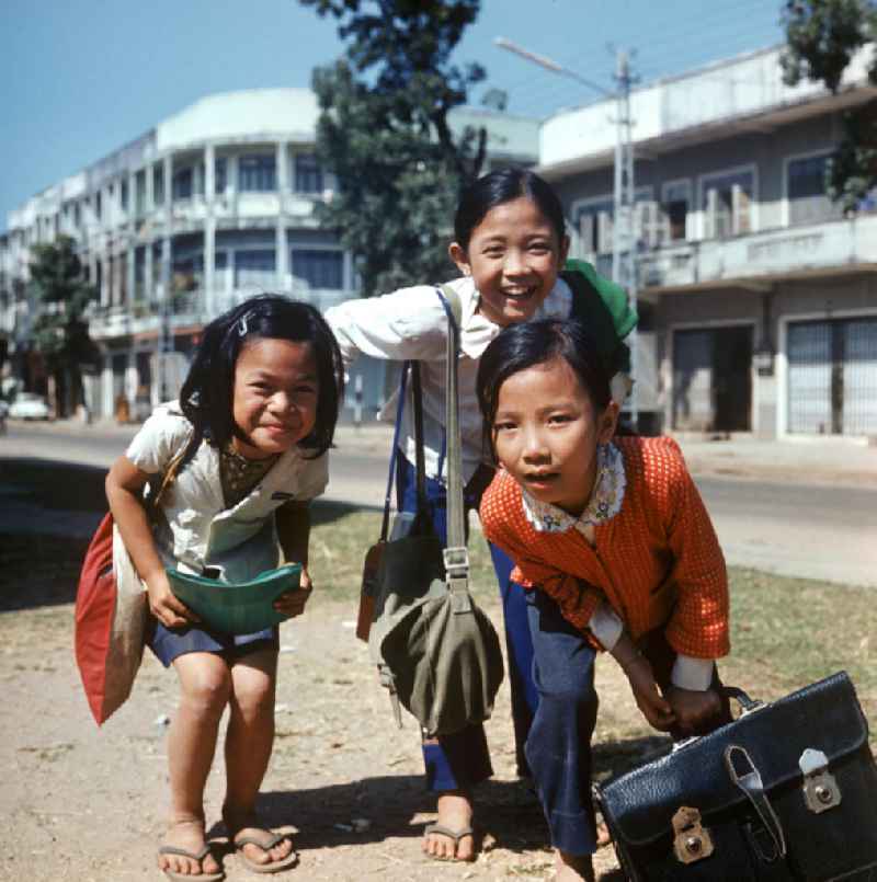 Mädchen blicken neugierig in die Kamera des Fotografen in Vientiane in der Demokratischen Volksrepublik Laos.