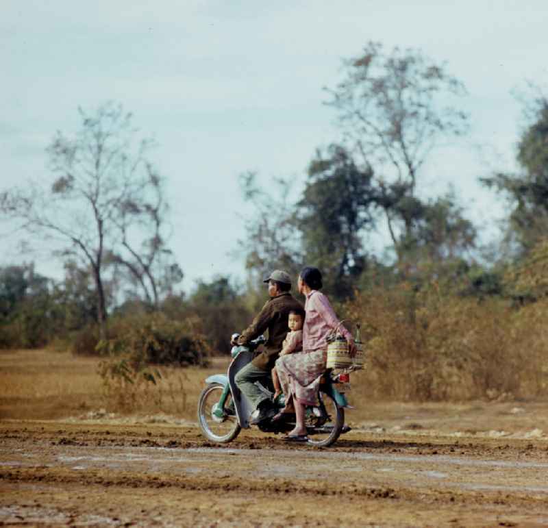 Familie auf einem Motorrad auf einer Straße in der Demokratischen Volksrepublik Laos.