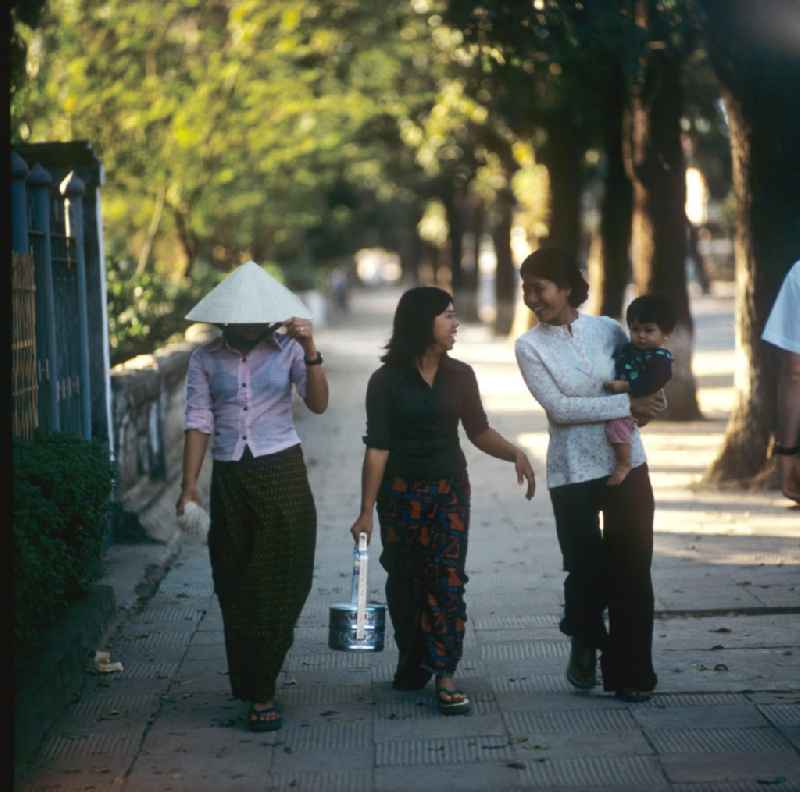Modisch gekleidete Frauen laufen auf einer Straße in Vientiane in der Demokratischen Volksrepublik Laos.