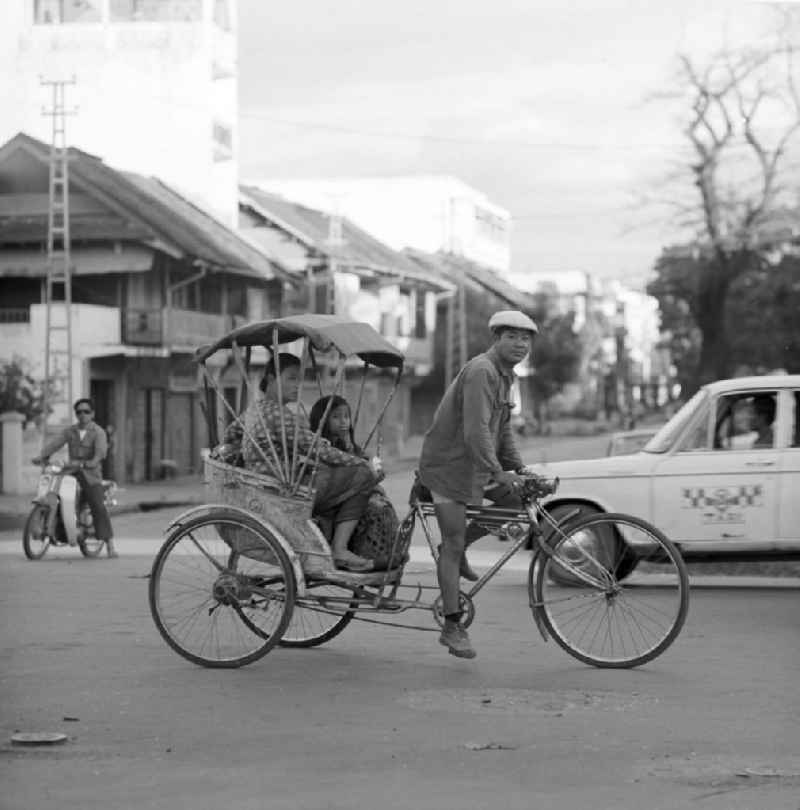 Rikschafahrer auf einer Straße in Vientiane in der Demokratischen Volksrepublik Laos.
