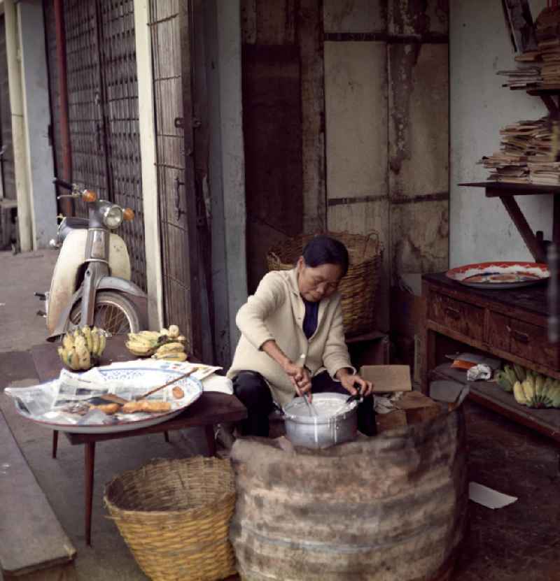 Eine Frau kocht Essen am Rande einer Straße in Vientiane in der Demokratischen Volksrepublik Laos.