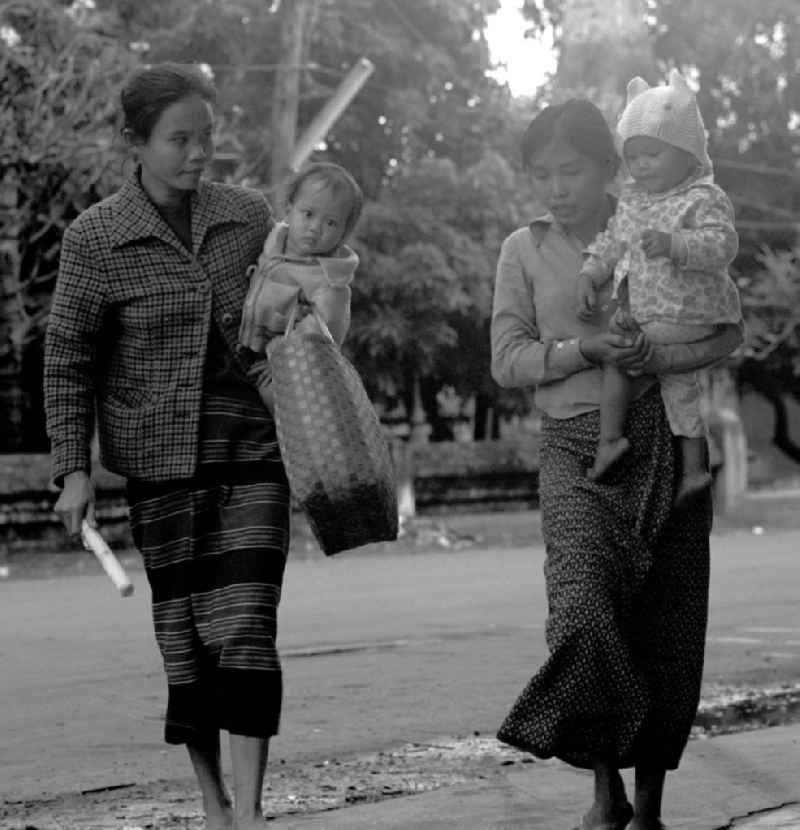 Frauen mit Kindern überqueren eine Straße in Vientiane in der Demokratischen Volksrepublik Laos.