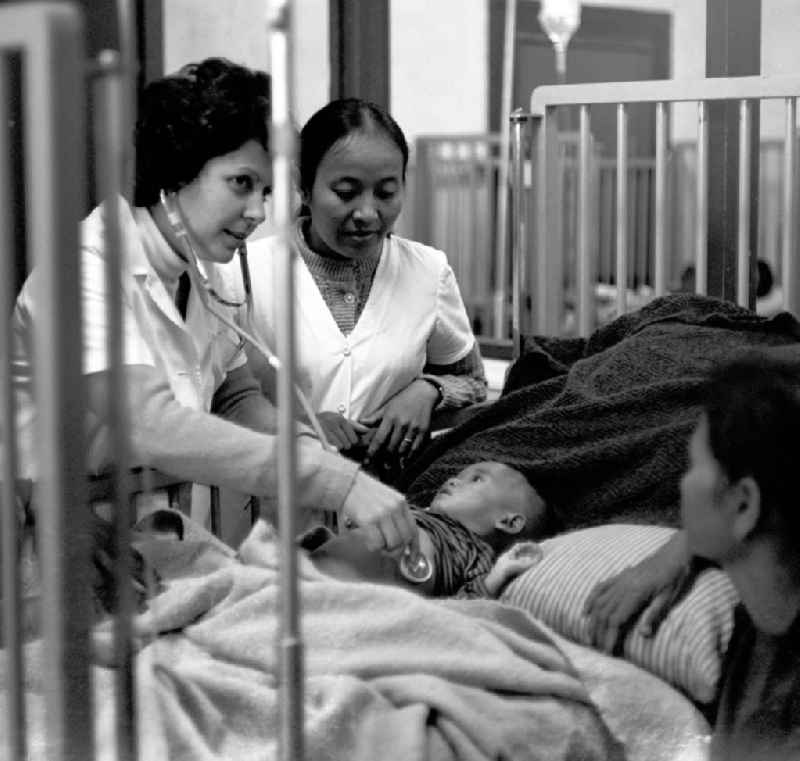 Eine kubanische Ärztin untersucht ein laotisches Kind in einem laotischen Krankenhaus in der Demokratischen Volksrepublik Laos.
