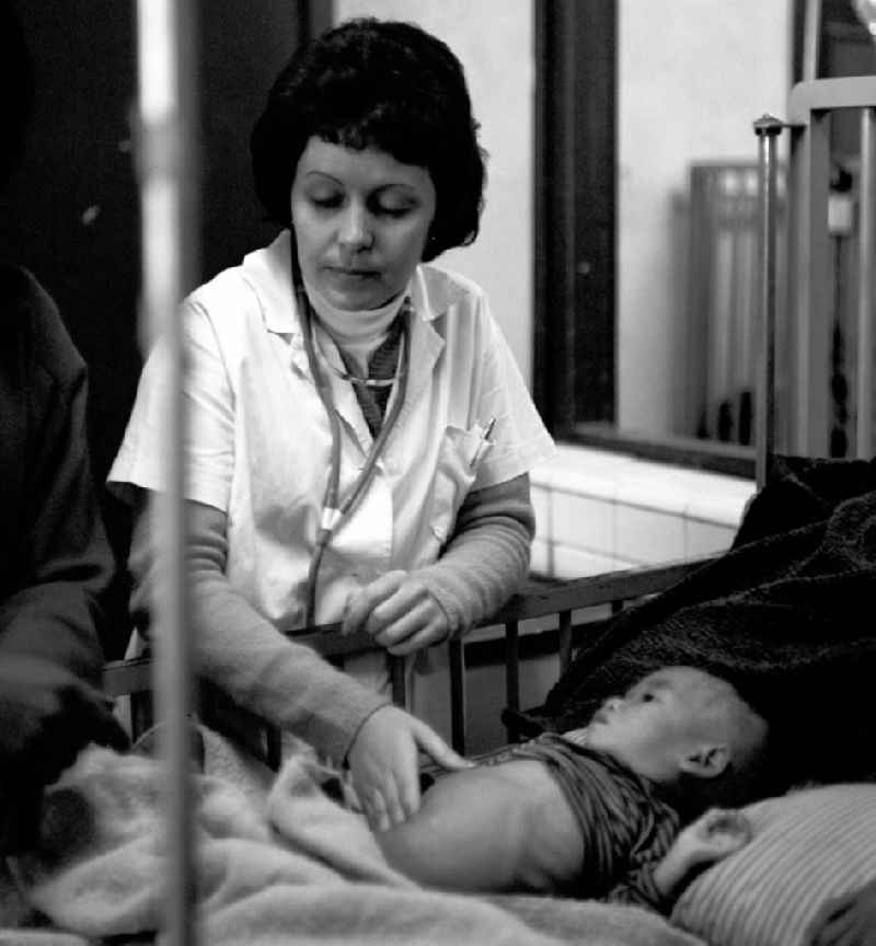 Eine kubanische Ärztin untersucht ein laotisches Kind in einem laotischen Krankenhaus in der Demokratischen Volksrepublik Laos.
