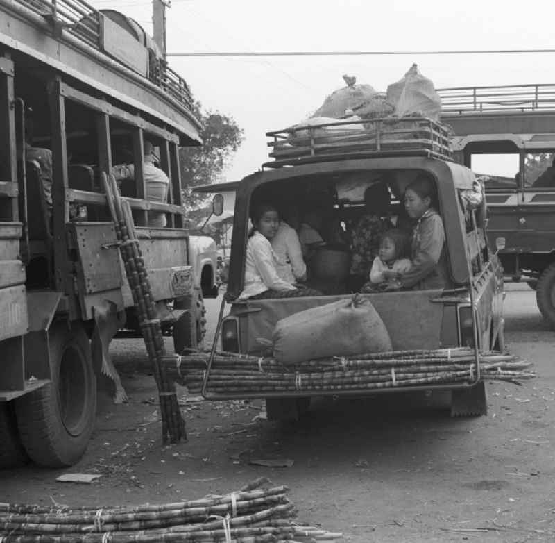 Mit Waren und Menschen vollbeladener Transporter auf einem Markt in Vientiane in der Demokratischen Volksrepublik Laos.