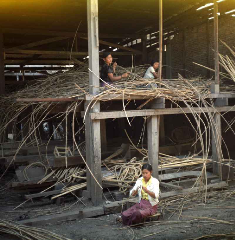 Frauen bei der Arbeit in einer Bambusmöbelfabrik in Vientiane in der Demokratischen Volksrepublik Laos.