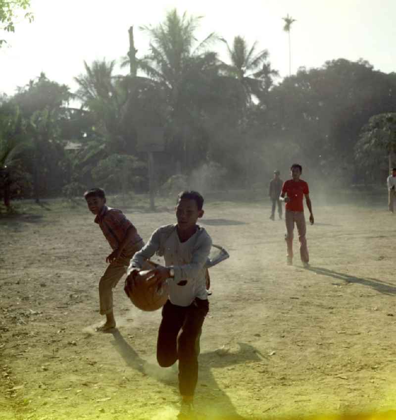 Kinder spielen Fußball auf einem Feld an der Schule in einem Dorf in der Demokratischen Volksrepublik Laos.