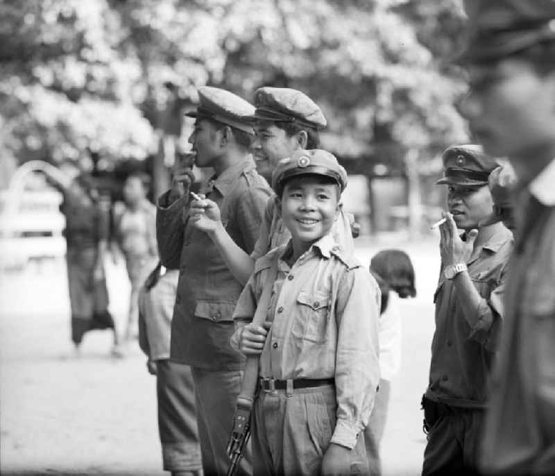 Männliche Milizionäre - unter ihnen noch ein Kind - in Uniform in Vientiane in der Demokratischen Volksrepublik Laos.