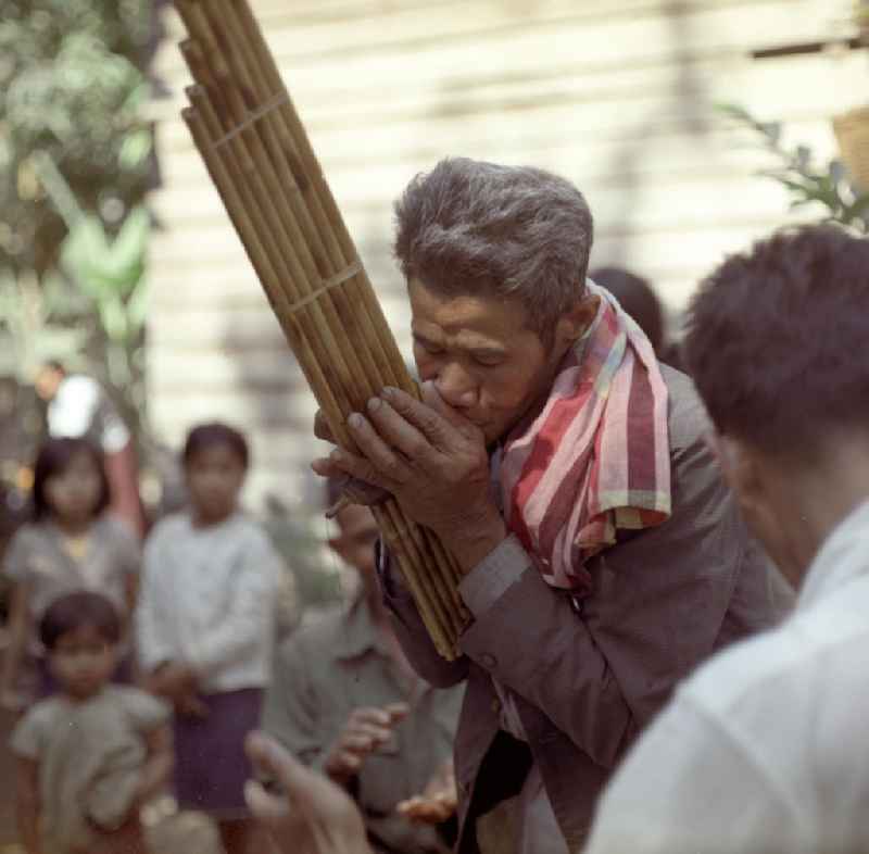 Ein Mann spielt auf einer Khaen zu einer Hochzeit in einem Dorf in der Demokratischen Volksrepublik Laos. Die asiatische Mundorgel ist das Nationalinstrument der Lao in Laos.