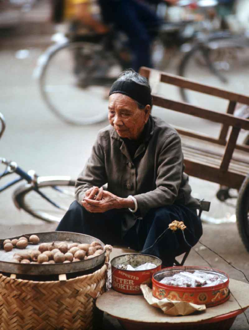 Eine alte Frau verkauft Lebensmittel am Rande des Marktes in Vientiane in der Demokratischen Volksrepublik Laos.
