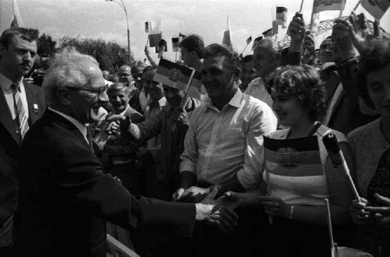 Staatsbesuch von Erich Honecker, Staatsratsvorsitzenden der DDR, in der Volksrepublik Polen. Honecker reicht einer jungen Frau die Hand. Drumherum jubelnde Schaulustige / Zuschauer mit DDR Fahnen / Fähnchen/ Flagge in der Hand.