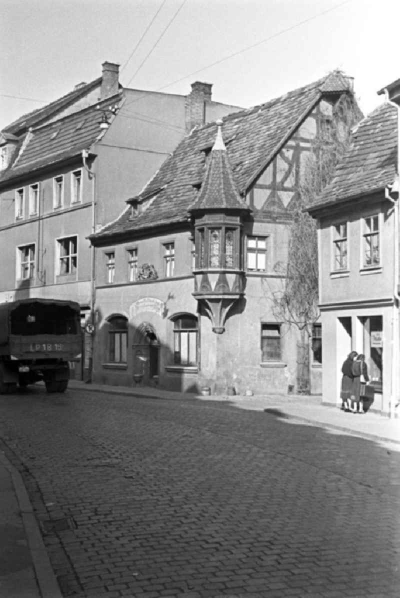 Alltagsszene in Weimar. LKW fährt auf Straße (Kopfsteinpflaster) vorbei an Wohnhäuser / Altbauten. Zwei Frauen stehen vor einen Schaufenster.