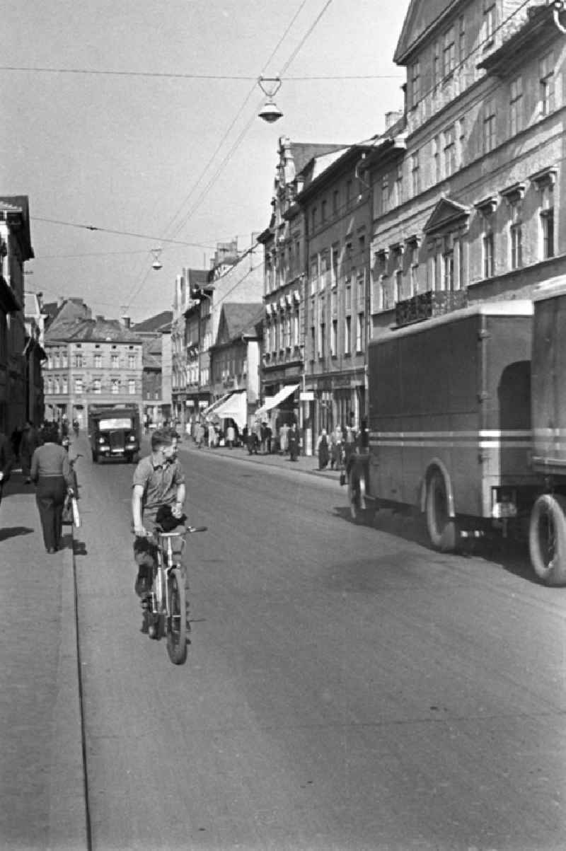 Alltagsszene in Weimar. Ein Junge fährt auf seinem Fahrrad auf einer Straße durch Weimar.