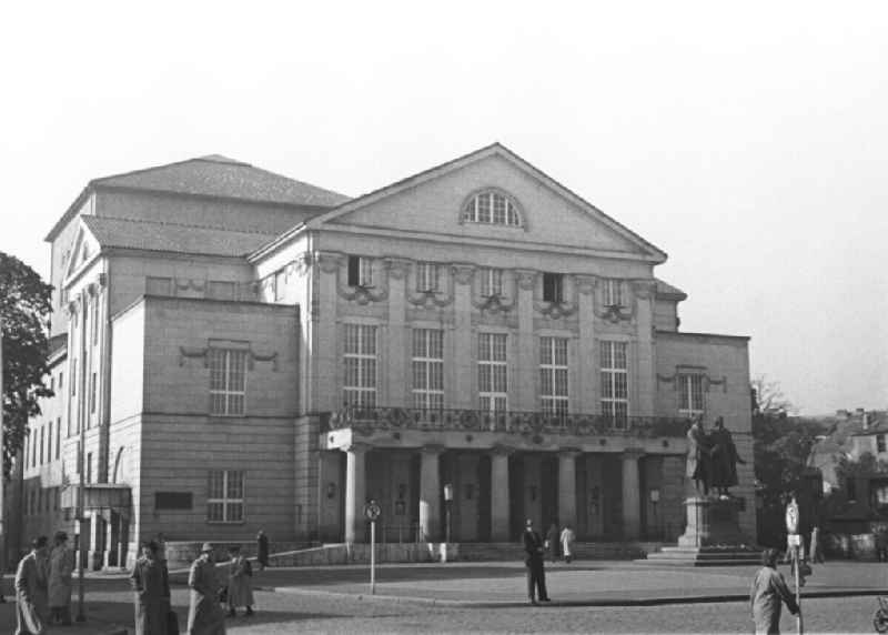 Deutsches Nationaltheater Weimar mit Goethe-Schiller-Denkmal auf dem Theaterplatz in Weimar. Vor dem Gebäude sind einige wenige Passanten zu sehen. Bestmögliche Qualität nach Vorlage!