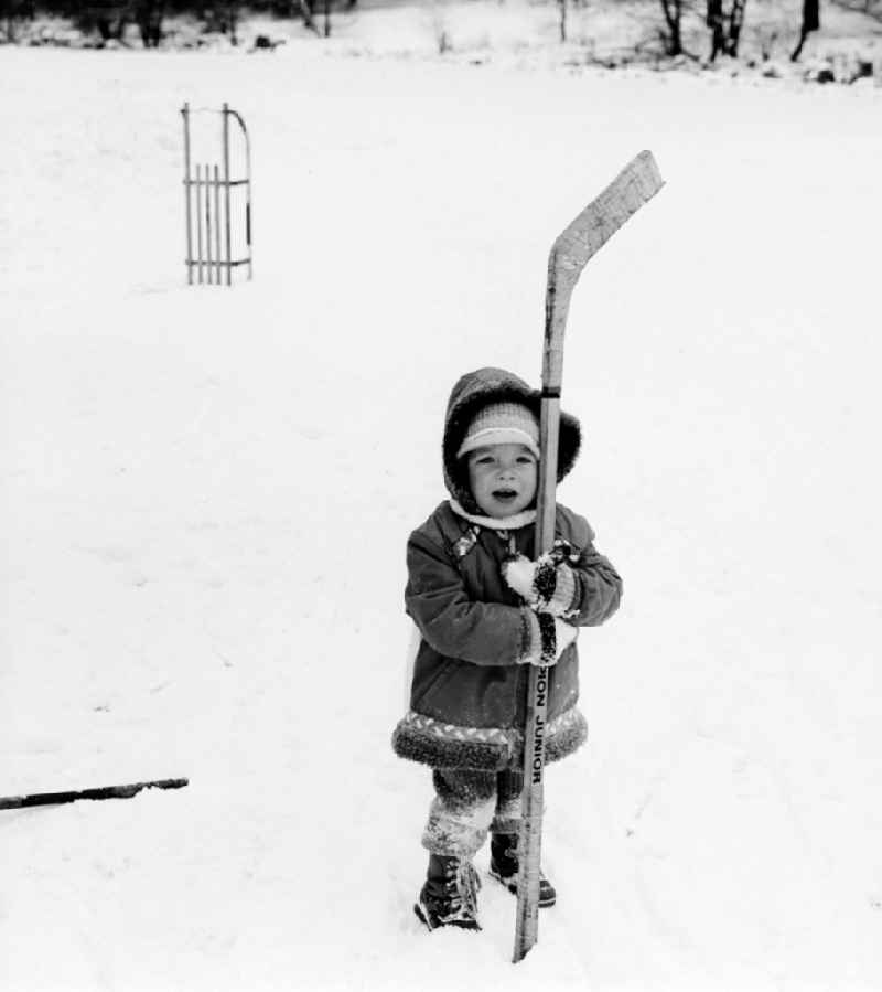 A small child with a hockey racquet in Wittstock / Dosse in the federal state Brandenburg in the area of the former GDR, German democratic republic