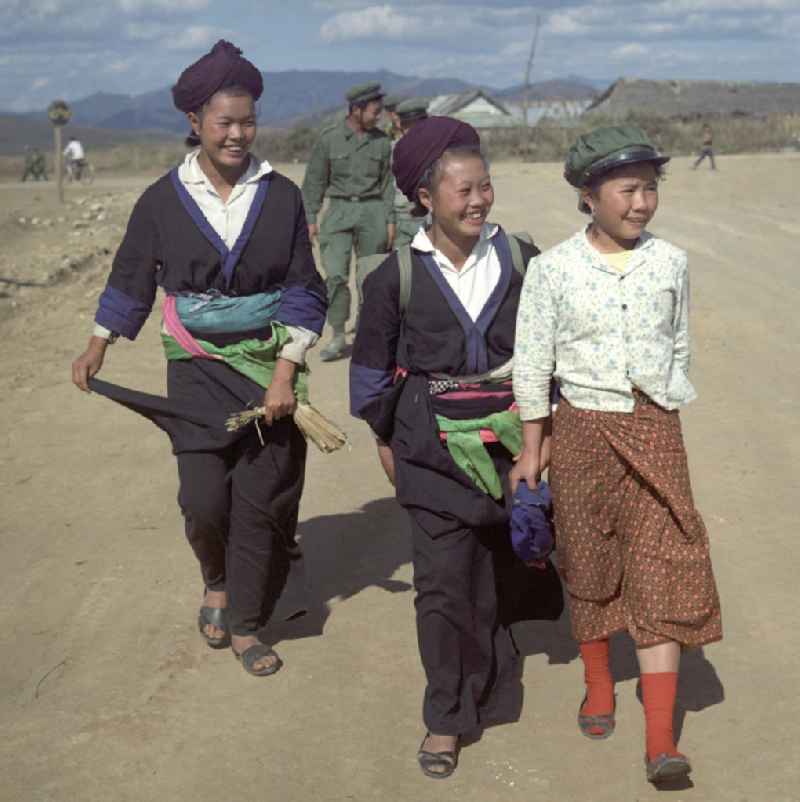 Frauen und Soldaten aus dem Volksstamm der Meo (auch Hmong) auf einer Straße nahe sogenannten 'Ebene der Tonkrüge' in der Provinz Xieng Khouang in der Demokratischen Volksrepublik Laos. Die Hmong waren im Vietnam-Krieg involviert. In dessen Folge gehörten sie zu einer verfolgten und zurückgezogen lebenden Minderheit in Laos.