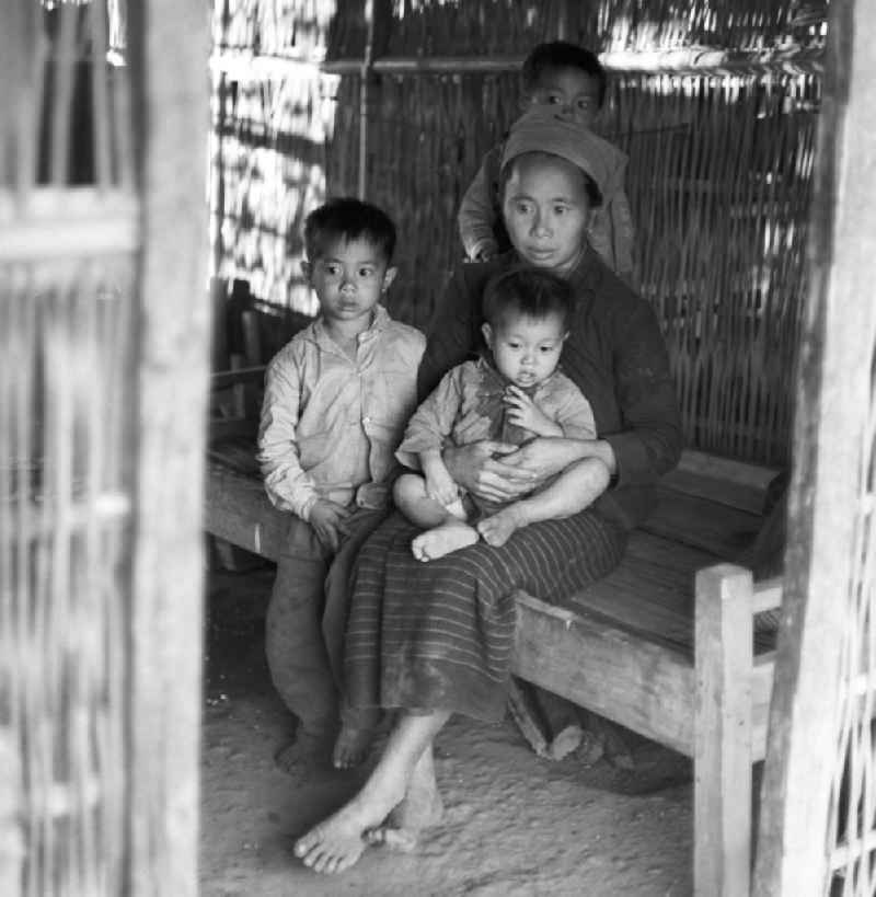 Frau mit Kindern aus dem Volksstamm der Meo (auch Hmong) im 'Kreiskrankenhaus' in einem Dorf an der sogenannten 'Ebene der Tonkrüge' in der Provinz Xieng Khouang in der Demokratischen Volksrepublik Laos. Die Hmong gehörten zu einer infolge des Vietnam-Krieges verfolgten und zurückgezogen lebenden Minderheit in Laos.
