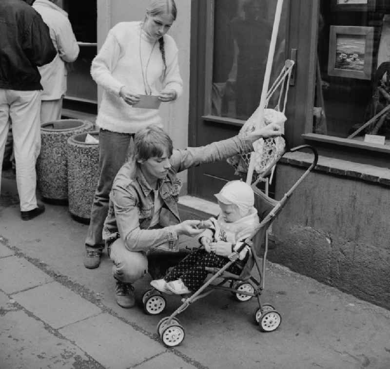 Young Family with a stroller in Zittau in the state Saxony on the territory of the former GDR, German Democratic Republic