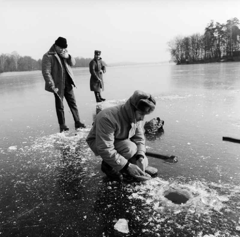 Ice fishing on the frozen Motzener See in Zossen in the federal state Brandenburg on the territory of the former GDR, German Democratic Republic