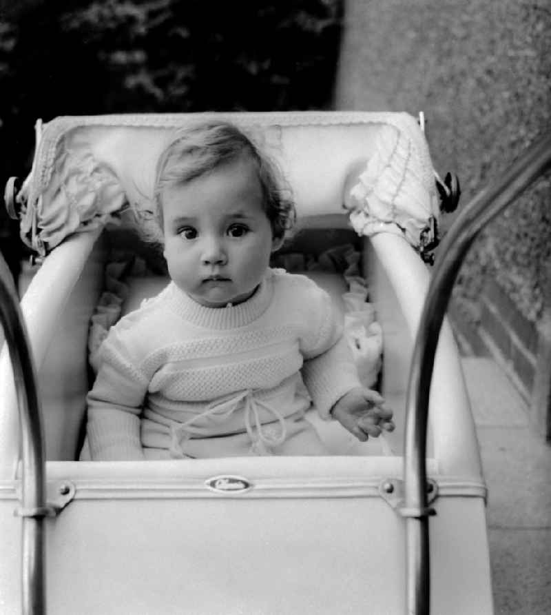 Small girl in a baby carriage in Zschopau in the federal state Saxony in the area of the former GDR, German democratic republic